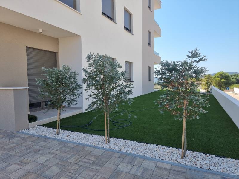 Exterieur einer 4-Zimmer-Wohnung in Vodice, eleganter Garten mit Bäumen und Rasen.