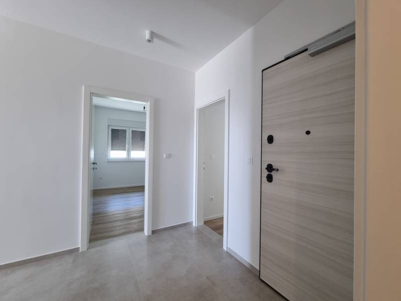 Eingangsflur in einer 4-Zimmer-Wohnung mit Holztüren und Fliesenboden.