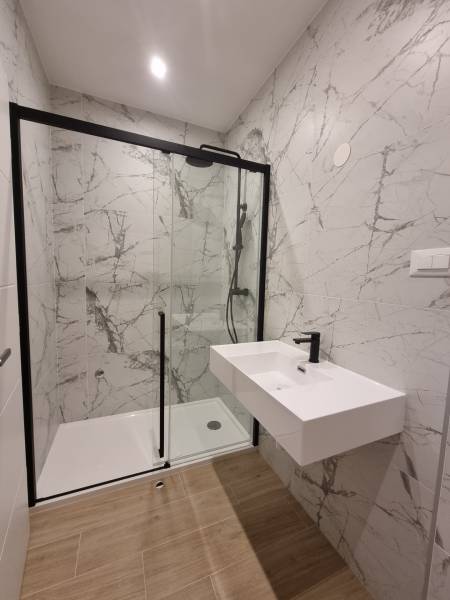 Duschkabine mit Waschbecken im Badezimmer einer 4-Zimmer-Wohnung, mit Marmorsternen.