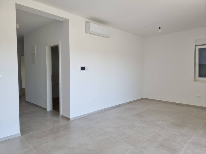 Helles Zimmer in einer 3-Zimmer-Wohnung mit Fliesenboden und Klimaanlage.