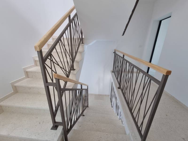 Eine Treppe mit einem Metallgeländer in einer 4-Zimmer-Wohnung.