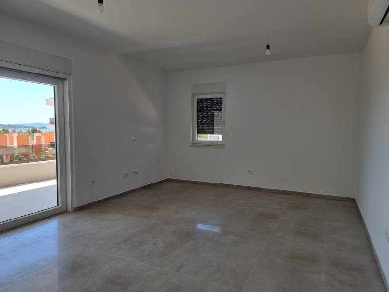 Geräumiges Zimmer einer 4-Zimmer-Wohnung mit Blick nach draußen durch Balkontüren.
