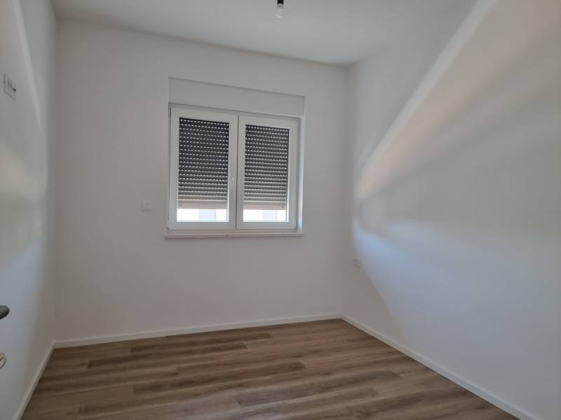 Innenraum einer 4-Zimmer-Wohnung mit weißen Wänden und Holzboden.