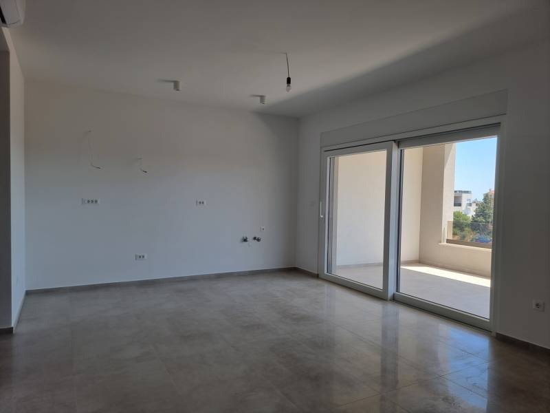 Ein geräumiges Zimmer in einer 4-Zimmer-Wohnung mit großen Fenstern und einem Balkon.