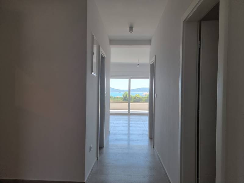 Badezimmer in einer 4-Zimmer-Wohnung mit Flur und Blick auf den Balkon.