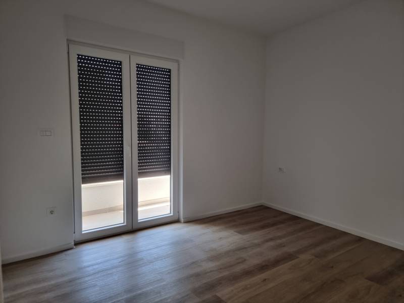 Ein Zimmer mit heruntergelassenen Jalousien und schwimmendem Boden in einer Vierzimmerwohnung.