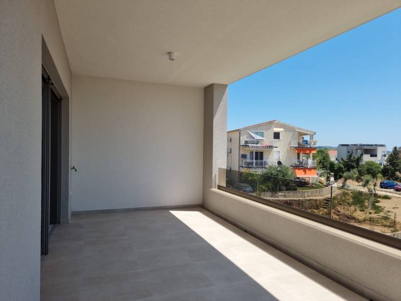 Ein Balkon in einer 4-Zimmer-Wohnung in Vodice mit Blick auf die umliegenden Gebäude und Grünflächen.