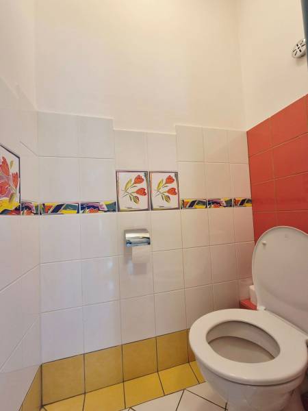 Toilette mit bunten Fliesen und Blumenmuster in Geschäftsräumen.
