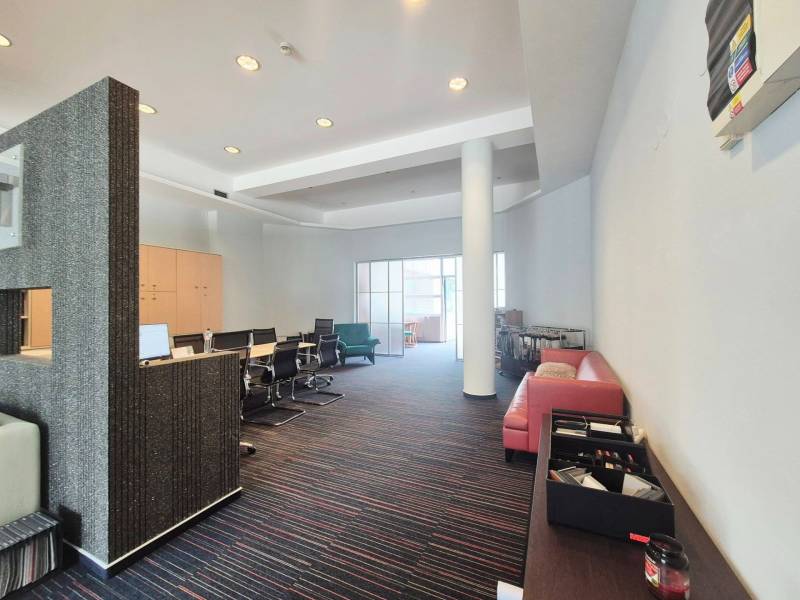 Gewerberäume mit Konferenztisch, rotem Sofa und modernen Möbeln.