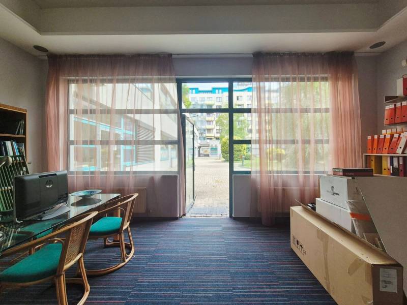 Gewerberäume mit Glaswand, Computer, Tisch und Regal mit Ordnern.