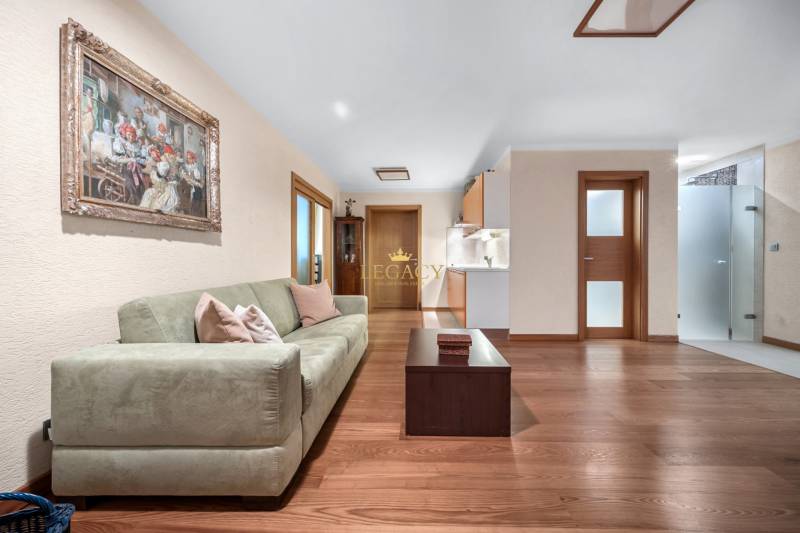 Wohnzimmer in einem Einfamilienhaus mit Sofa, Tisch und Kunstbild an der Wand.