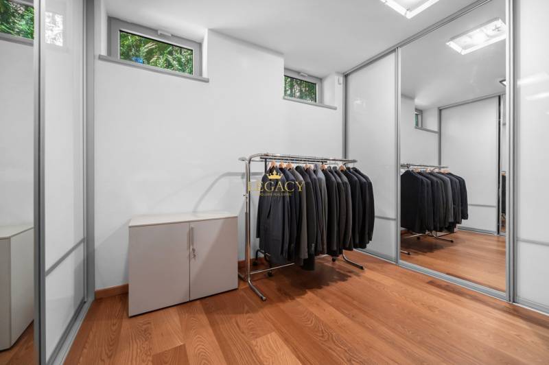 Ein Kleiderschrank in einem Einfamilienhaus mit einem Spiegelschrank und Kleiderbügeln für Kleidung.