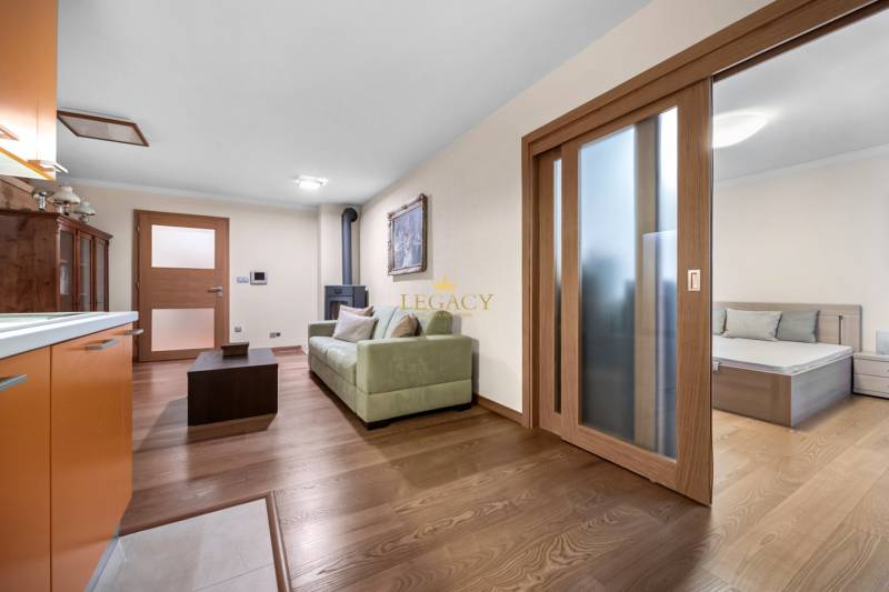 Wohnzimmer und Küche in einem Einfamilienhaus, mit Holzboden und Kamin.