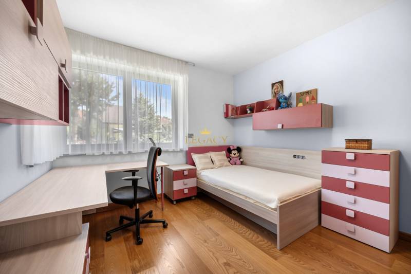 Kinderzimmer in einem Einfamilienhaus mit Bett, Schreibtisch und Dekorationen.