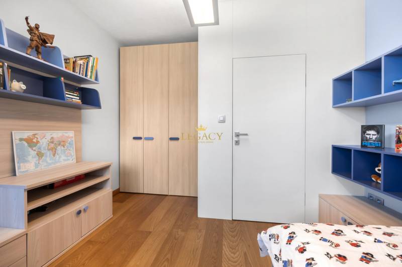 Kinderzimmer in einem Einfamilienhaus mit Holzboden und Regalen voller Bücher.