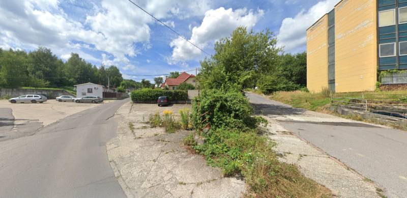 Grundstücke - Gewerbeflächen in der Štrajkova-Straße in Handlová, mit Grünflächen und Parkplatz.
