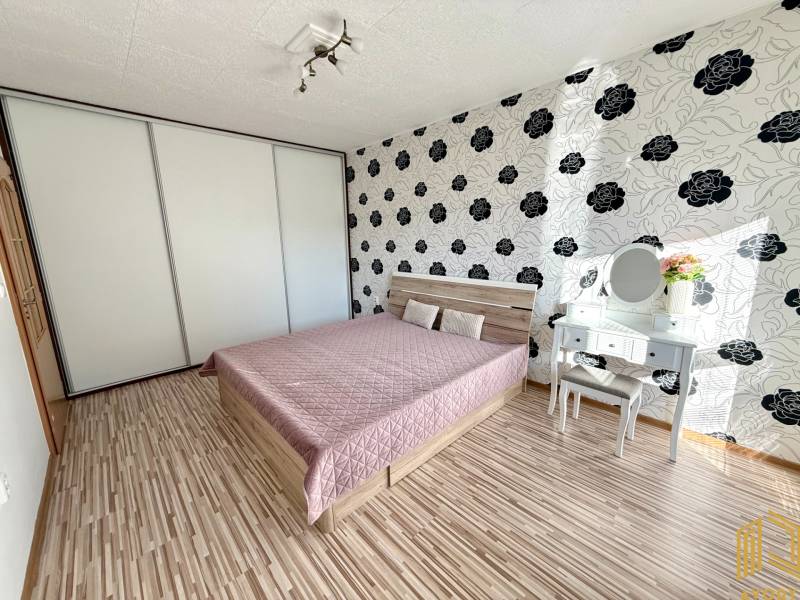 Schlafzimmer in einer 2-Zimmer-Wohnung mit Bett, Einbauschrank und Schminktisch.