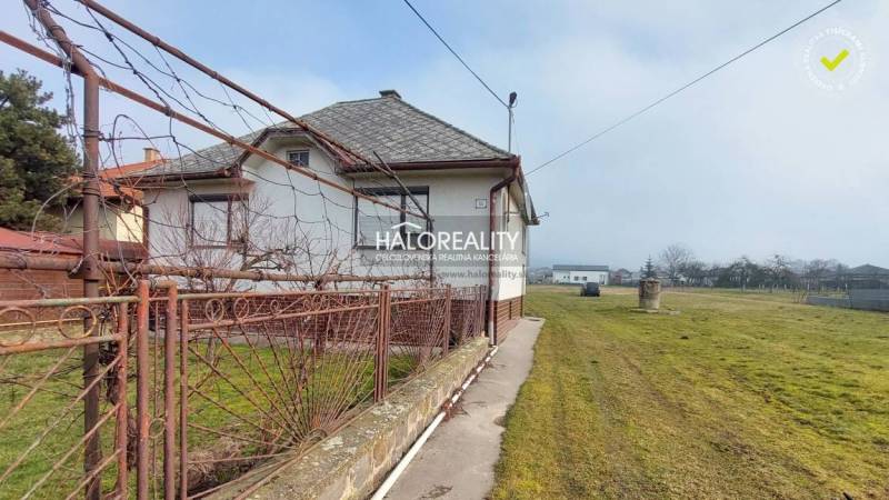 Hof eines Einfamilienhauses mit weitläufigem Rasen und altem Zaun in Ruskov. Grundstücke - Wohnen.