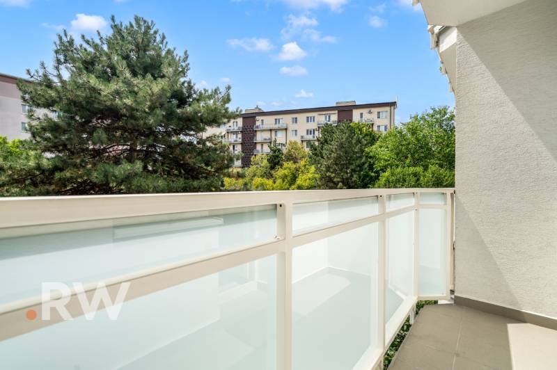 Ein Balkon mit Blick auf Grünflächen und Wohnhäuser in Bratislava - Nové Mesto.