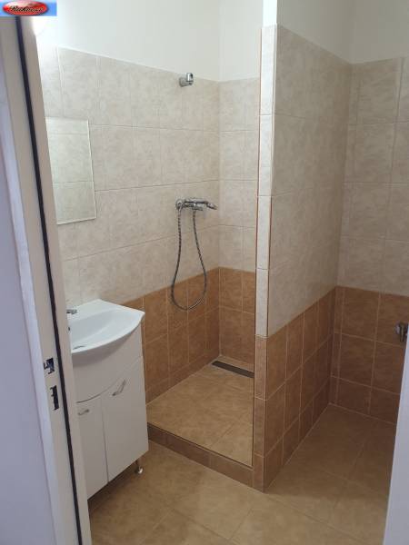 Badezimmer einer 3-Zimmer-Wohnung mit Badewanne und Waschbecken, gefliest mit hellen Keramikfliesen.