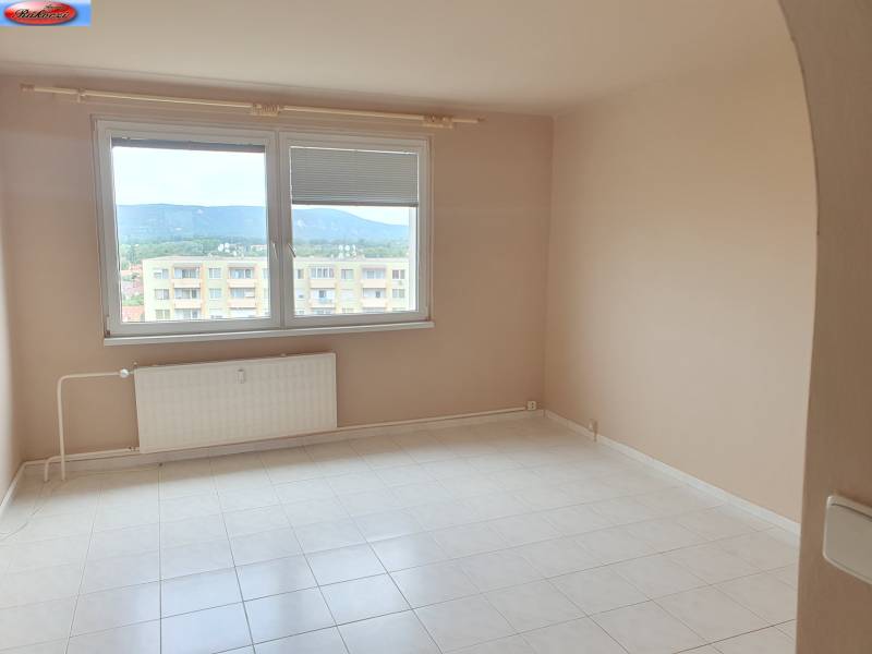 Ein Zimmer in einer 3-Zimmer-Wohnung mit weißem Boden und einem großen Fenster mit Aussicht.