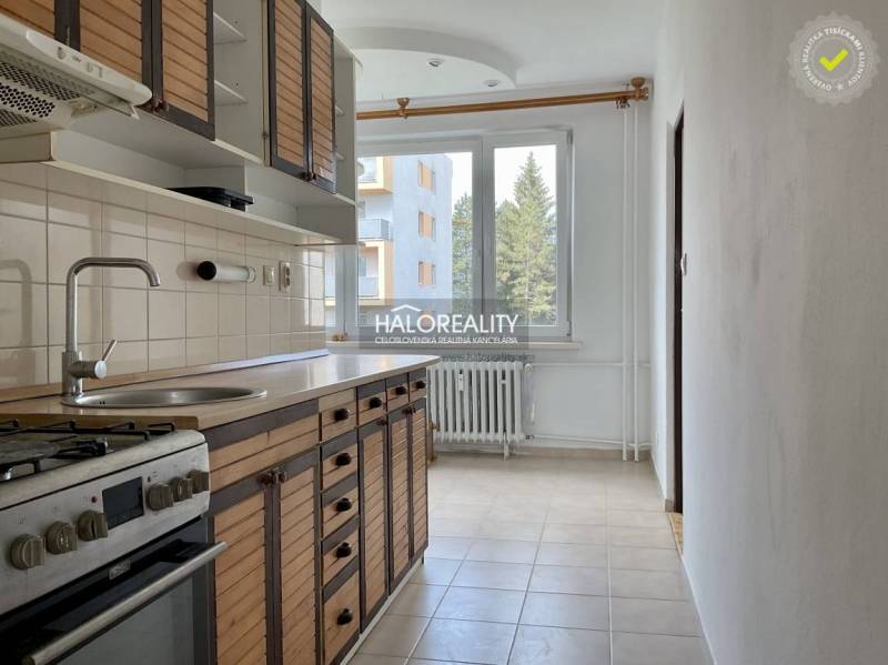 Küche in einer 3-Zimmer-Wohnung mit Holzküche, Herd und Fenster mit Heizkörper.