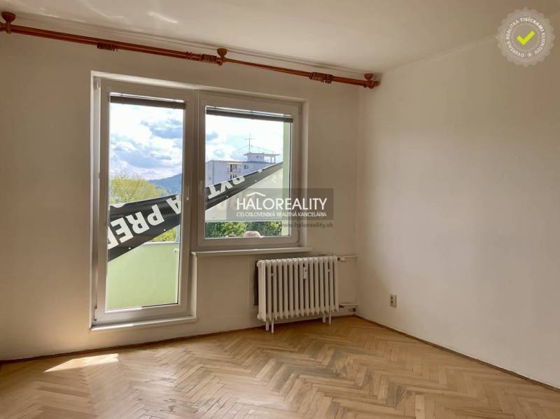 Ein Zimmer mit Parkettboden und einem großen Fenster in einer 3-Zimmer-Wohnung.