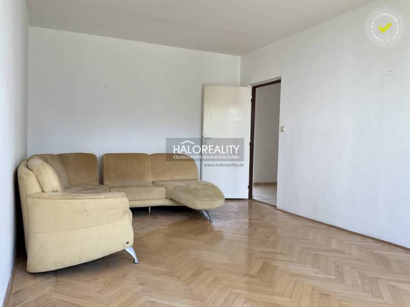 Wohnzimmer in einer 3-Zimmer-Wohnung mit beigem Sofa und Parkettboden.
