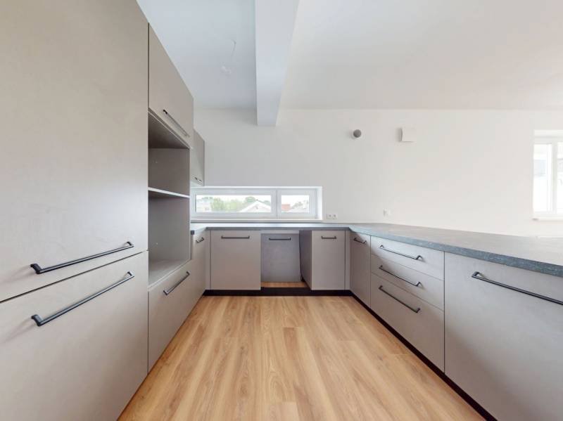 Küche in einer 3-Zimmer-Wohnung mit hellen Schränken und Holzböden.