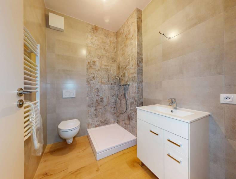 Badezimmer in einer 3-Zimmer-Wohnung mit Toilette, Dusche und Waschbecken.