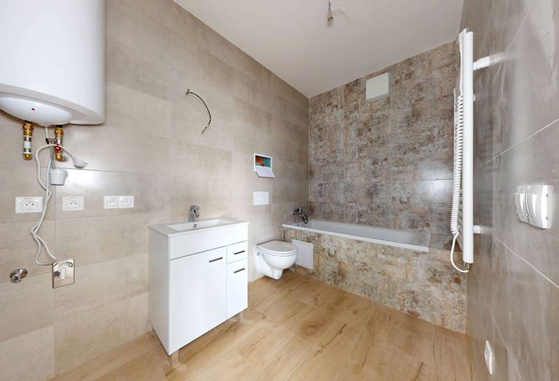 Badezimmer in einer 3-Zimmer-Wohnung mit Badewanne, Waschbecken und hängendem WC.
