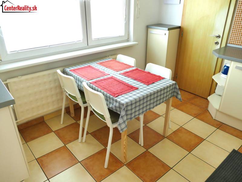 Esszimmer mit Holztisch und vier Stühlen in einer 3-Zimmer-Wohnung, kariertem Boden.