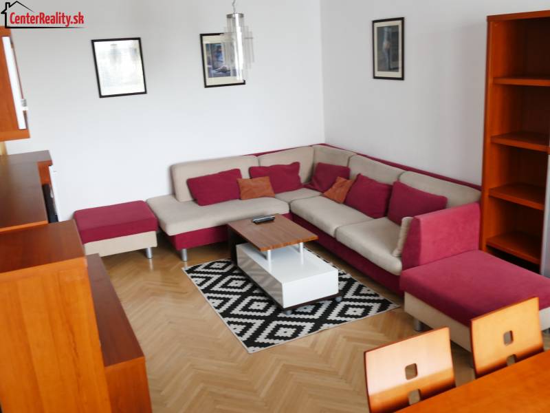 Wohnzimmer einer 3-Zimmer-Wohnung mit Ecksofa und Holzmöbeln.