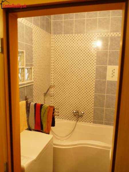 Badezimmer mit Dusche in einer 3-Zimmer-Wohnung, mit Keramikfliesen bedeckt.