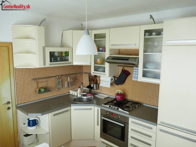 Küche in einer 3-Zimmer-Wohnung mit Küchenzeile, Geräten und orangefarbenen Fliesen.