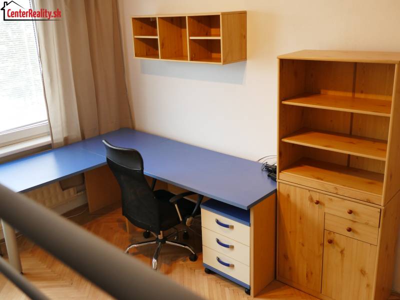 Heimbüro mit blauem Schreibtisch und Holzmöbeln in einer 3-Zimmer-Wohnung.