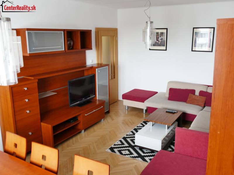 Wohnzimmer in einer 3-Zimmer-Wohnung mit einer Holzwand-Einheit und einer Ecksofagarnitur.