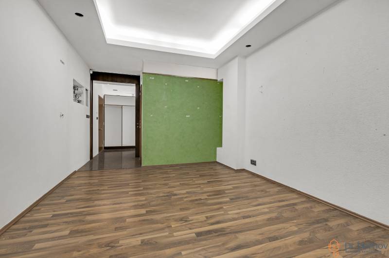 Ein Innenraum mit Holzboden und grüner Wand in Geschäftsräumen.