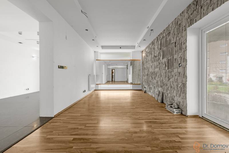 Gewerberäume mit Holzboden und Steinwand, geeignet für verschiedene Nutzungen.