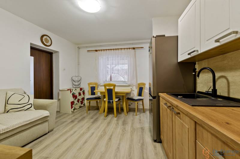 Küche und Essbereich in einer 2-Zimmer-Wohnung mit hellen Möbeln und Holzboden.
