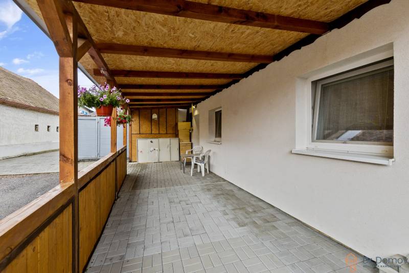 Überdachte Terrasse neben einer 2-Zimmer-Wohnung in Malé Leváre mit Blumendekorationen.