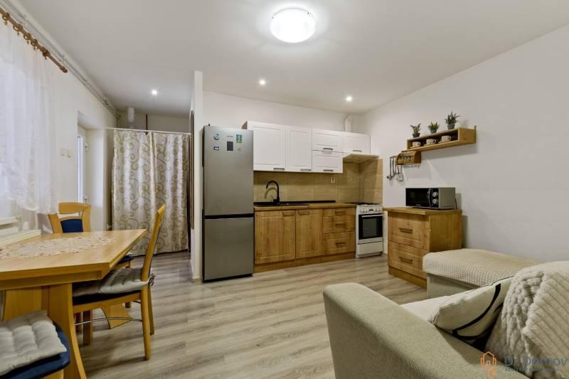 Küche und Esszimmer in einer 2-Zimmer-Wohnung mit Holzelementen und Einrichtung.