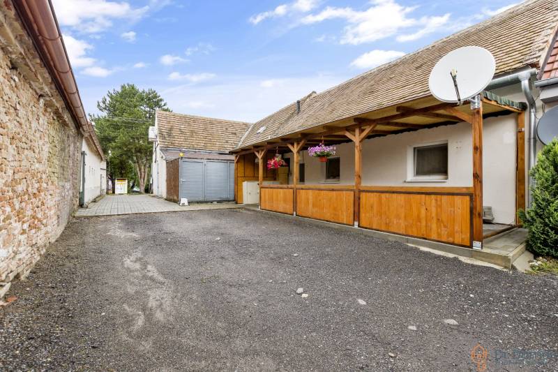 Hofraum bei einer 2-Zimmer-Wohnung in Malé Leváre mit Fliesen und Holzpergola.