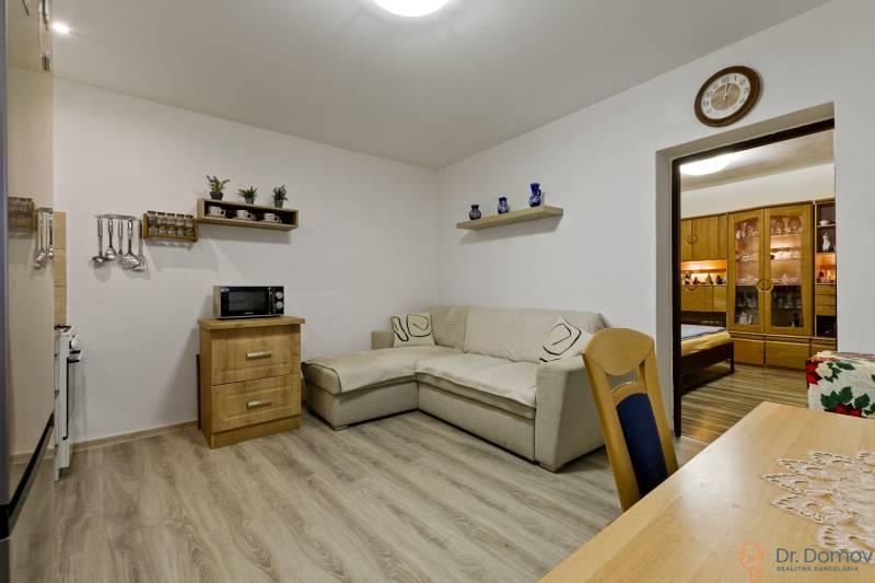 Wohnzimmer mit Sofa, Holzmöbeln und Regalen in einer 2-Zimmer-Wohnung.