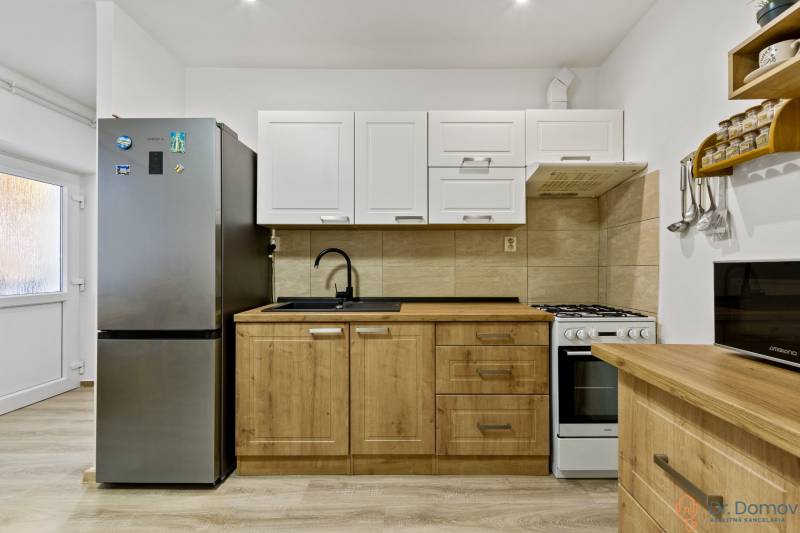 Küche mit Herd und Kühlschrank in einer 2-Zimmer-Wohnung.