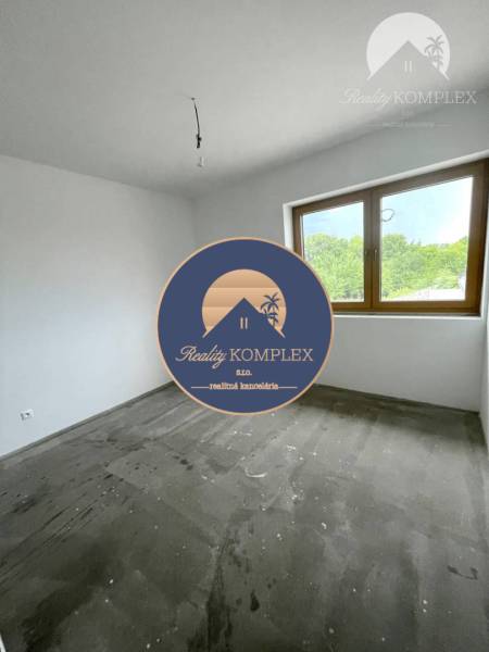 Ein Zimmer in einem Einfamilienhaus mit weißen Wänden und einem großen Fenster.