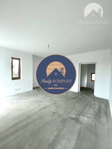 Ein geräumiges Zimmer in einem Einfamilienhaus mit Betonboden und weißen Wänden.