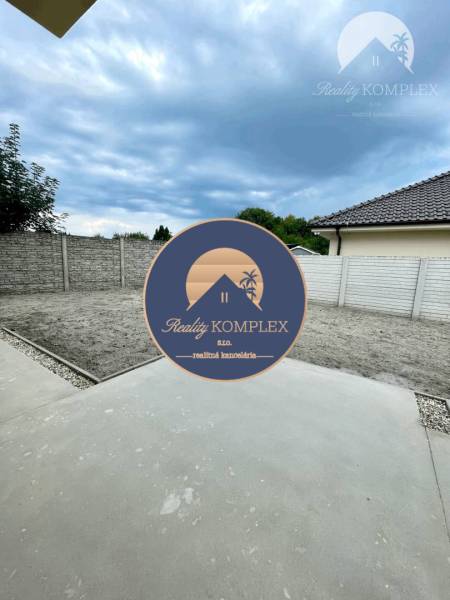 Der Hof des Einfamilienhauses in Čukáraboni in Dunajská Streda mit einer gemauerten Mauer und Pflastersteinen.