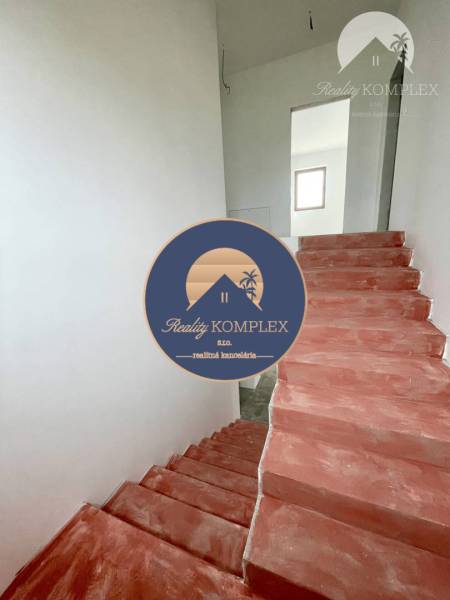 Im Einfamilienhaus gibt es Betontreppen und weiße Wände, die in den oberen Stock führen.