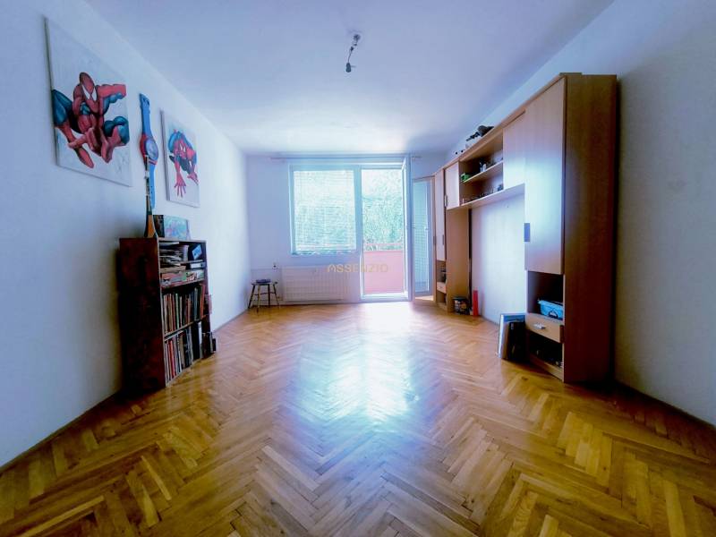 Wohnzimmer in einer 3-Zimmer-Wohnung mit Parkettboden, Möbeln und Wanddekorationen.